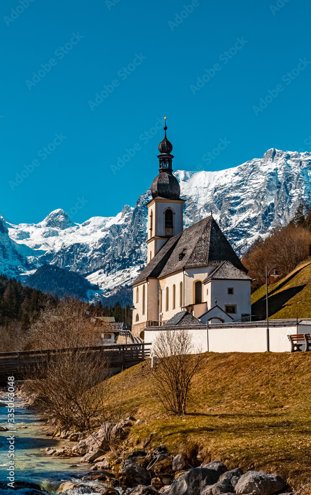 The famous church Saint Sebastian at Ramsau, Berchtesgaden, Bavaria, Germany on a sunny morning with the snow-covered alps in the baclground