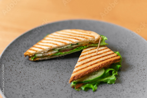 Sandwich on a gray plate on a wooden table.