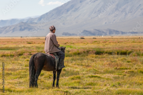 Altai, Mongolia - June 14, 2017: Nomad with his faithful horse in the steppes of Mongolia. Horseback in Mongolia. Mongolian valley view