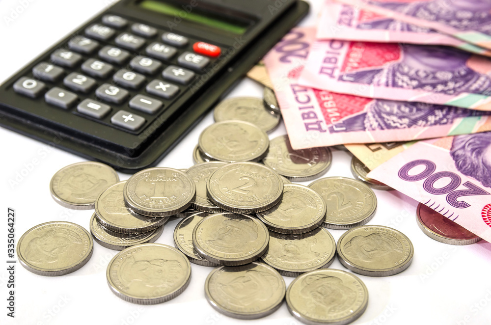 200 hryvnia, coins and calculator on a white background. Business concept. Ukrainian money on white. 200 hryvnia, coins and calculator on a white background. Business concept. Ukrainian money on white.