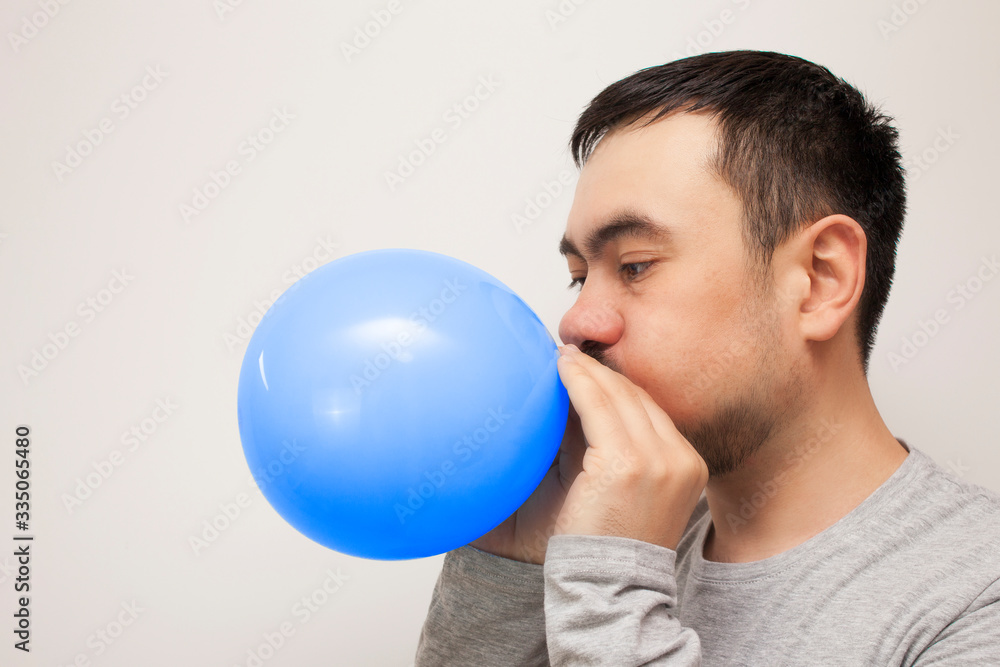 Man inflating a blue balloon. Bearded man with balloon. Man inflating a blue balloon. Bearded man with balloon.