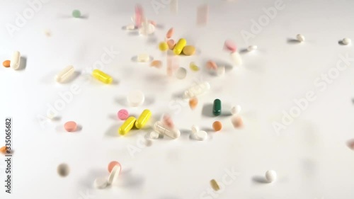 A huge number of pills falling on white background top view close up