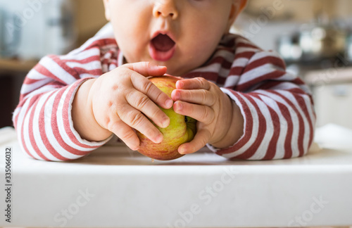 Healthy cute caucasian baby boy have, eat vegan raw supplementary food at home in his highchair. Vegan infant concept.