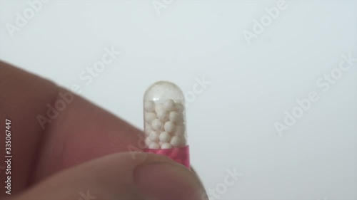 Medicine, capsule with pellets in man's fingers.Close up