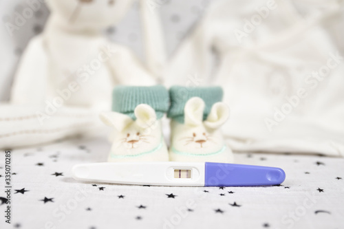 Green and white baby booties and pregnancy test. new life concept. new parents.