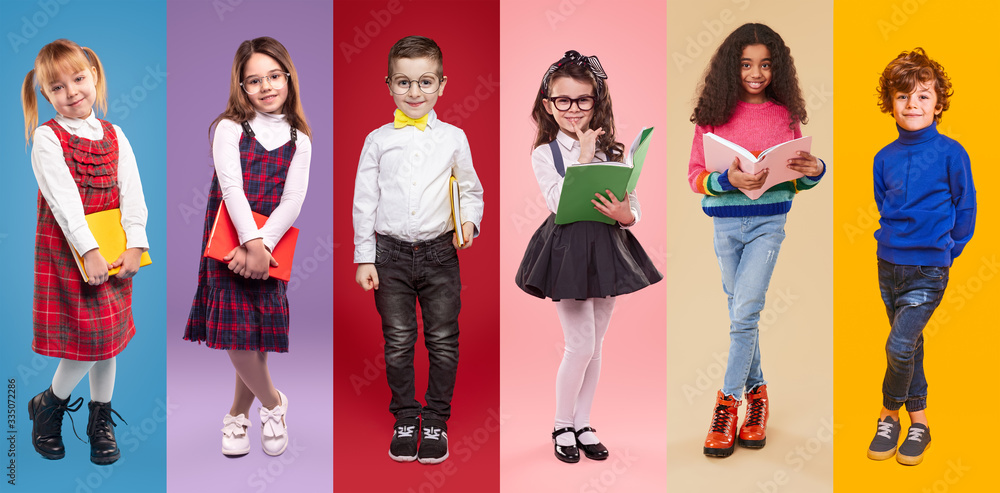 Obraz premium Positive schoolkids with books looking at camera