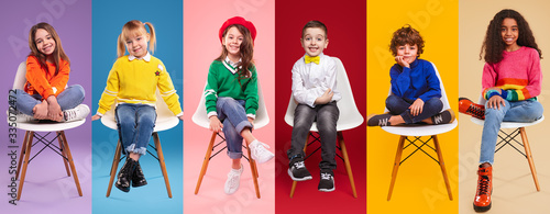 Cheerful kids in stylish clothes sitting on chairs