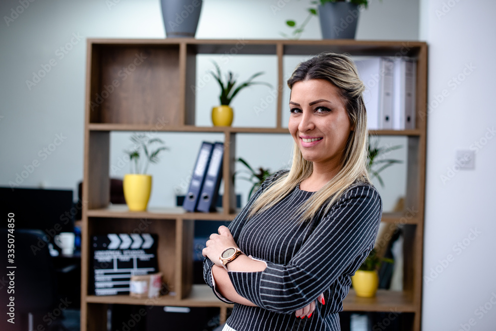 Attractive blonde woman standing in front of office shelves Attractive blonde woman standing in front of office shelves