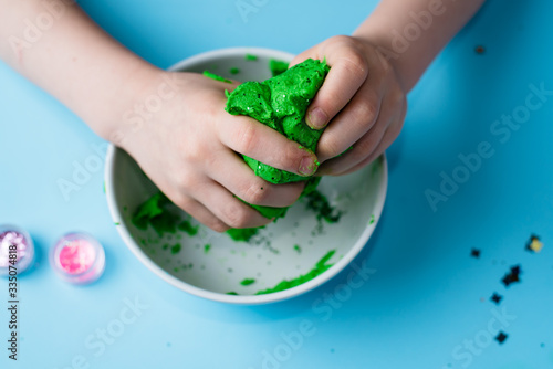 Child hands playing with colorful clay. Homemade plastiline. Plasticine. play dough. Girl molding modeling clay. Homemade clay.