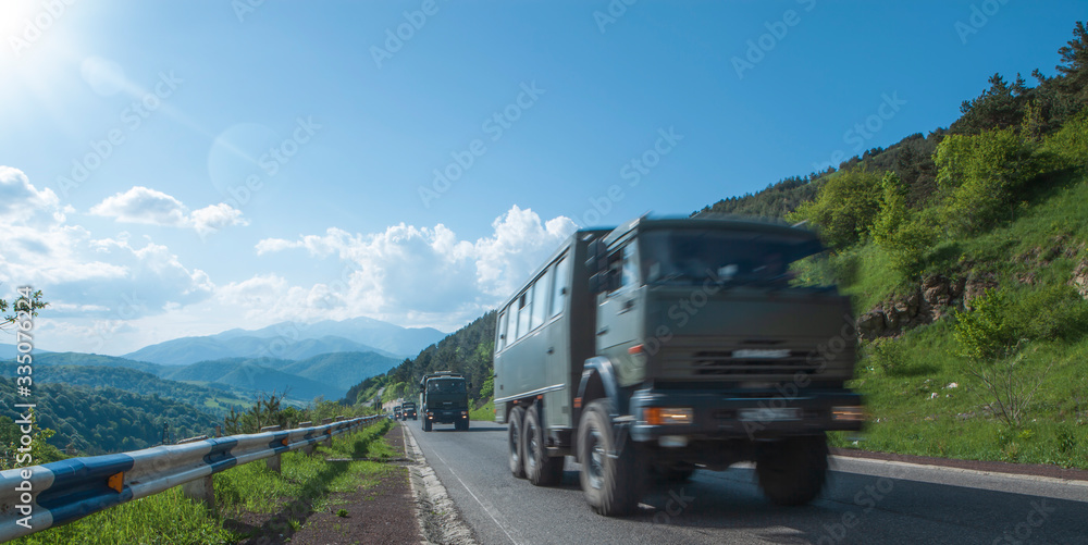 convoy of military trucks rides on the highway