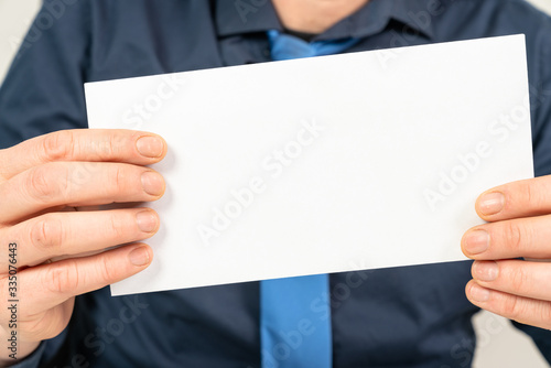 person holds a letter envelope in the camera