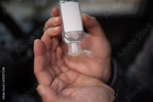 Hands of man that applying alcohol gel to make cleaning and clear germ, bacteria, Health care concept in car. coronavirus, disease, infection, quarantine, covid-19