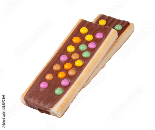 Chocolate bar snack with colorful drops or dragee isolated on the white photo