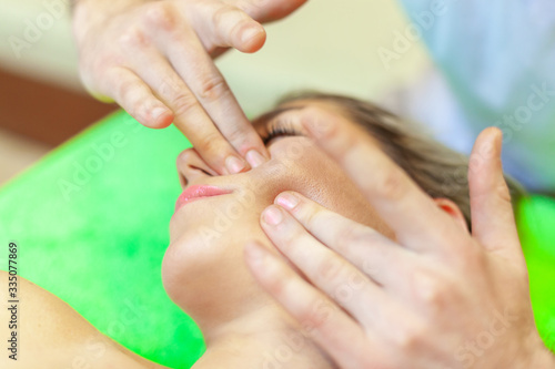 Photo of a part of face of calm female during luxurious procedure of massage