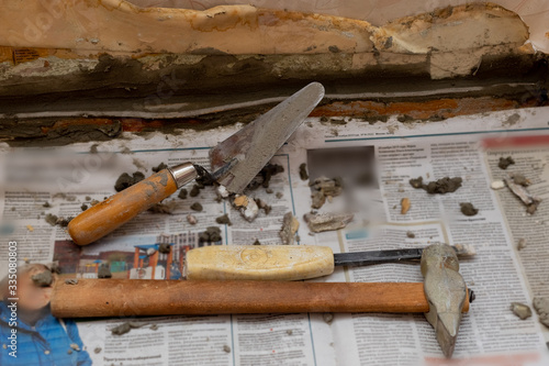 Trowel and cement on the newspaper. Construction works. Home repair. Do it yourself.