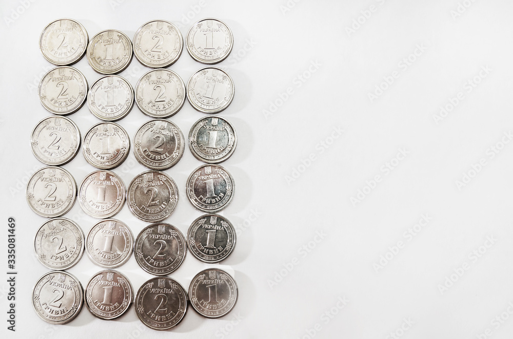 Ukrainian coins 1 and 2 hryvnia on white. Copy space. Ukrainian pennies for the background. Ukrainian coins 1 and 2 hryvnia on white. Copy space. Ukrainian pennies for the background.