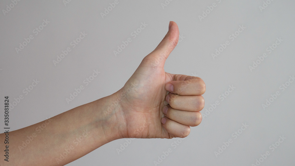 Thumb up of a left female hands on white background.