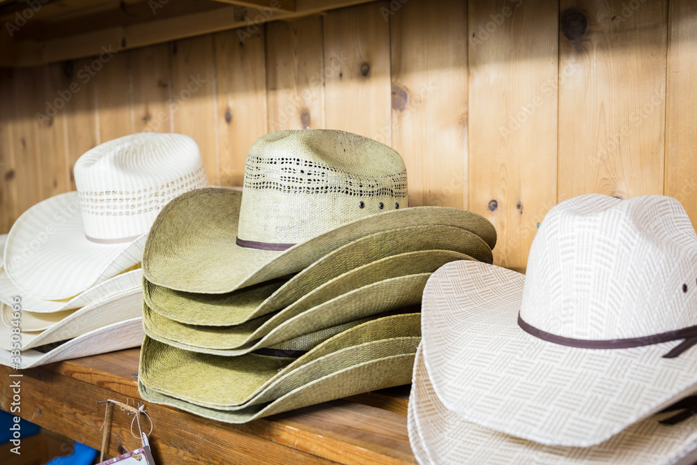 Cowboy hats on a wooden shelf in a store