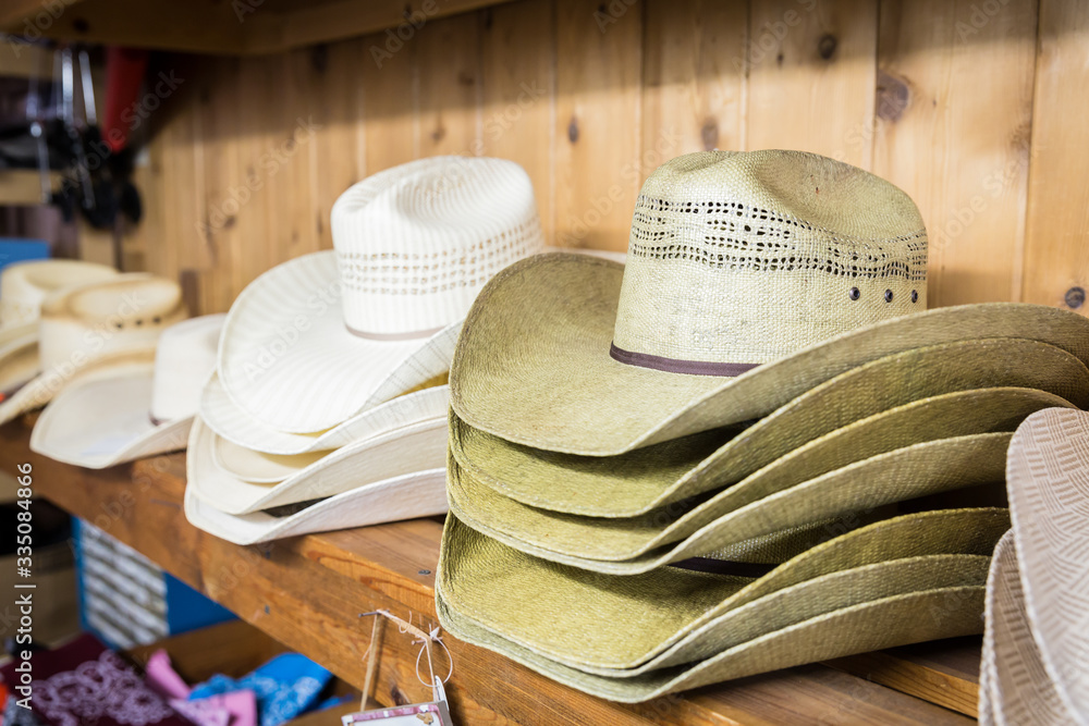 Cowboy hats on a wooden shelf in a store