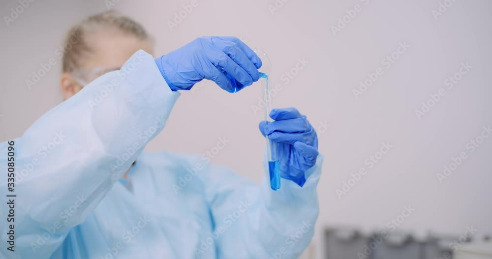 Female Scientist Holding Tubes and Flask with Liquid in Hands. Female Scientist Holding Tubes and Flask with Liquid in Hands.