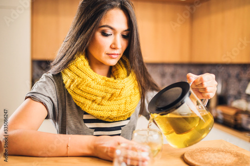 Caucasian woman pours a hot ginger drink with lemon to raise and strengthen immunity in order to prevent the virus photo