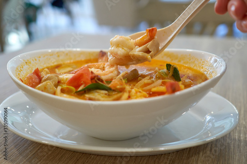 Hot Tom Yam Kung soup with shrimps in thai restaurant in Bangkok, Thailand.