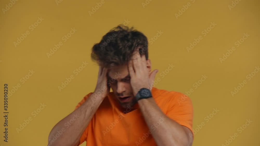 Tired man having migraine isolated on yellow Tired man having migraine isolated on yellow