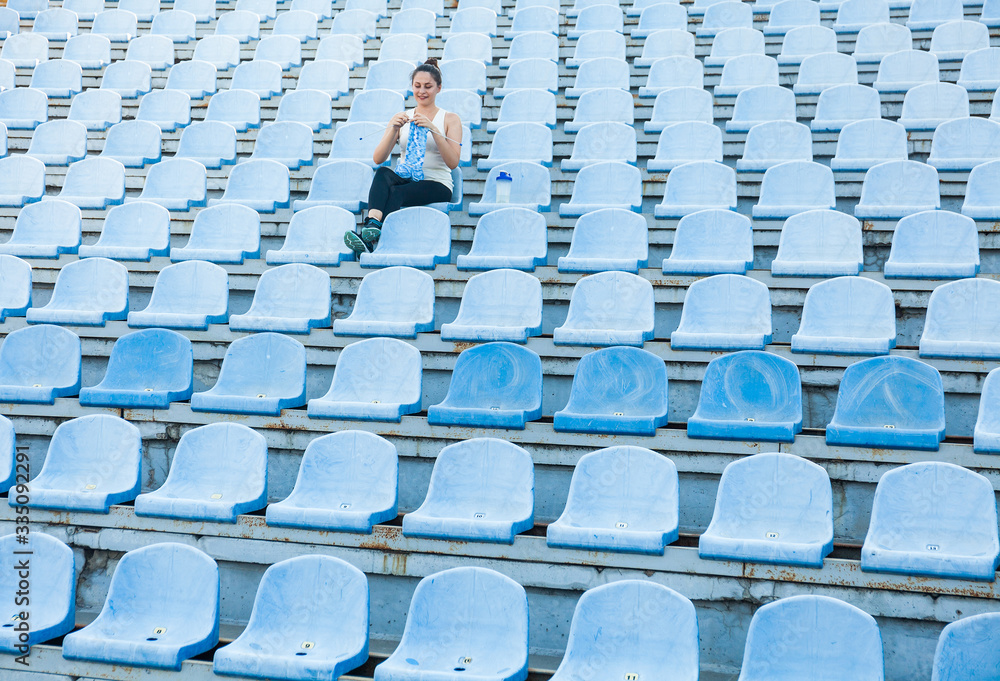 Fototapeta premium Woman athlete knitting a sweater on a football field