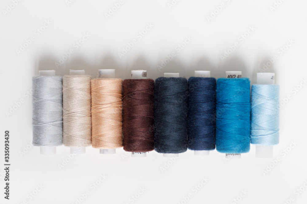 close-up of colored sewing threads on a light background with a place for the inscription.