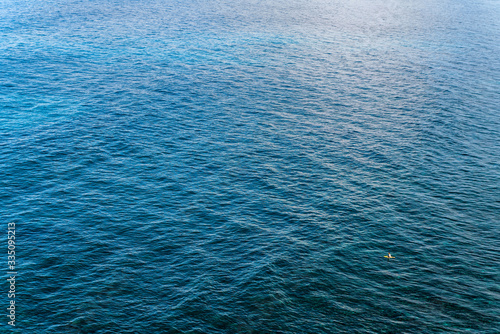 The smooth surface of the ocean. The ocean near the Bukit Peninsula in Indonesia. Azure sea natural background.