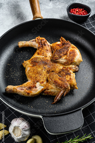 Grilled chicken with pepper and rosemary. Gray background. Top view