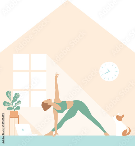 Fit woman doing yoga morning workout and watching online tutorials on laptop