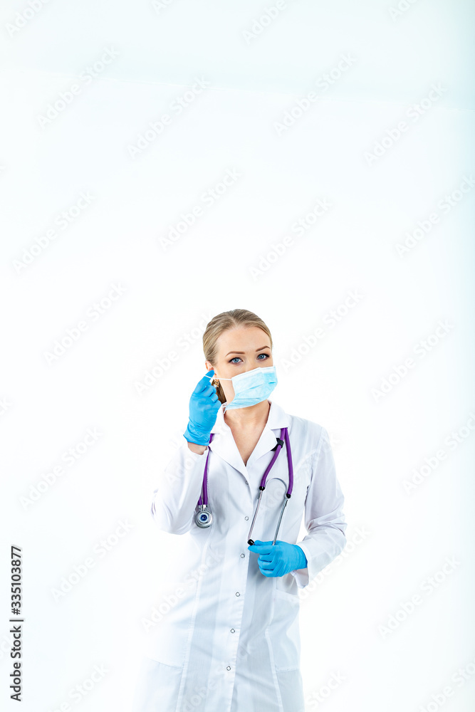 doctor nurse puts on a protective mask. A nurse in a respiratory mask. Put on masks. Wear gloves. beautiful blonde doctor shows how to put on a protective respiratory mask isolated on a white backgrou doctor nurse puts on a protective mask. A nurse in a respiratory mask. Put on masks. Wear gloves. beautiful blonde doctor shows how to put on a protective respiratory mask isolated on a white backgrou