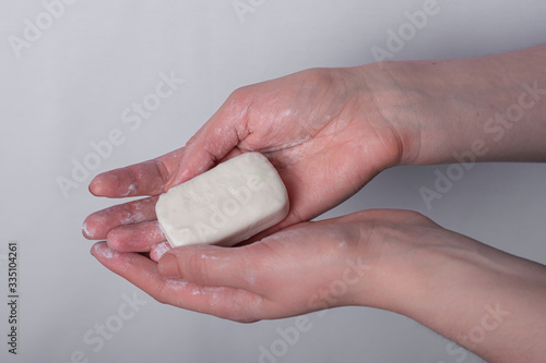 Women's hands are holding soap. personal hygiene and cleanliness help in the fight against germs, coronavirus bacteria and viruses obtained after bodily contact and handshakes