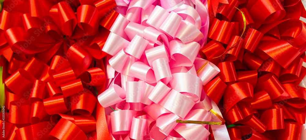 Curly red ribbon and pink background. Texture background. Patten background. Curly red ribbon and pink background. Texture background. Patten background.