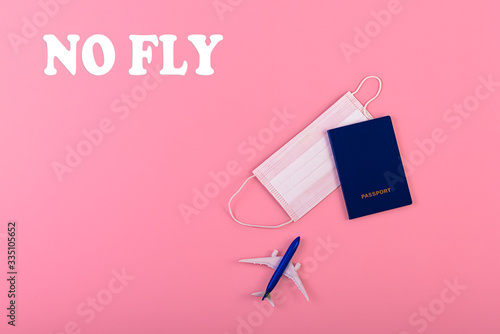 Surgical mask, plane and passport on pink background. Virus protection equipment. Dangerous asian ncov coronavirus. Concept of fly danger photo