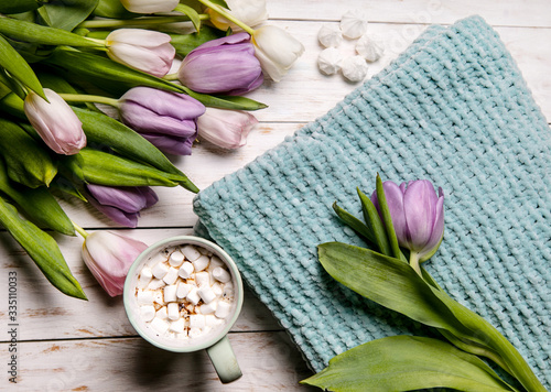 Fototapeta Naklejka Na Ścianę i Meble -  Turquoise plaid cup of cocoa decorated with marshmallows, white tulips. Positive postcard Flat lay, top view,Mother day