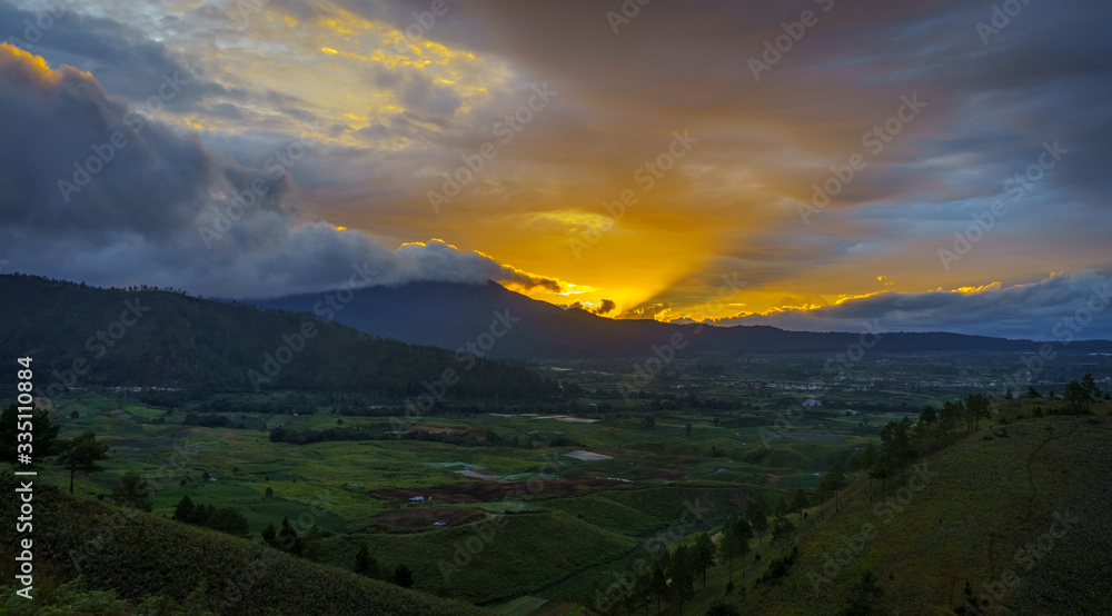 Vibrant vivid golden sunset over Karo batak highlands hills near to lake Toba or Medan