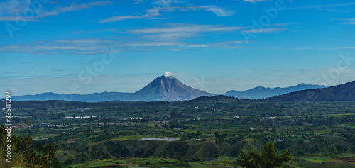 Gunung Sinabung active volcano mountain seen from lake Toba. Beautiful scenery Karo batak farm lands near Berastagi photo