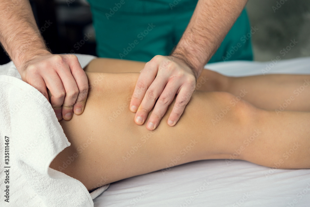 Male hands does Lymphatic drainage massage of the hips.