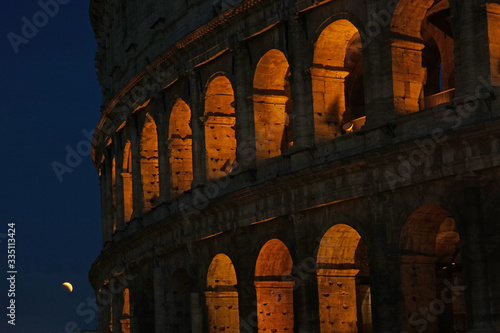 The Colosseum, or Flavian Amphitheater, in Rome, Italy with a lunar eclipse.