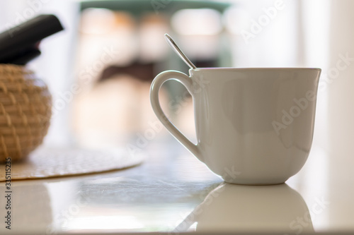 Cup with spoon on white table