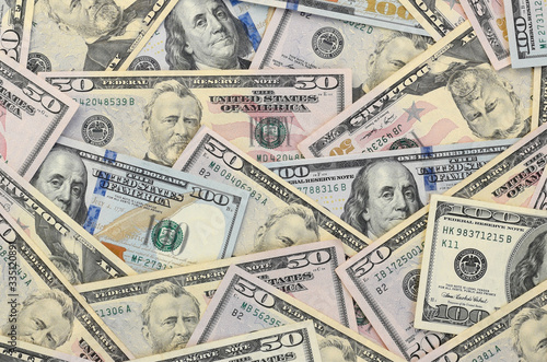 Many one hundred and fifty dollar bills on flat background surface close up. Flat lay top view photo