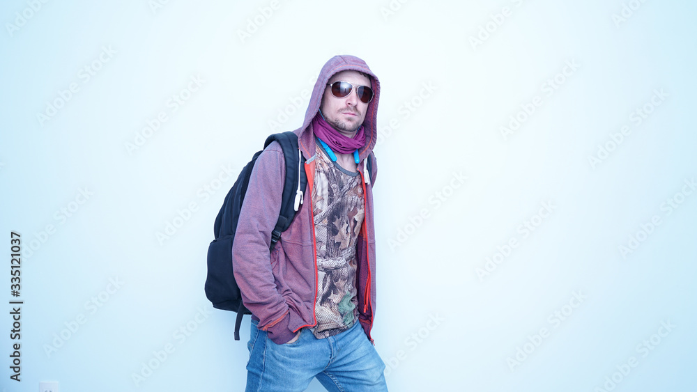 Emotional funny guy in earphones and sunglasses with bag.Portrait of young man in hood with happy emotions and smile on his face.