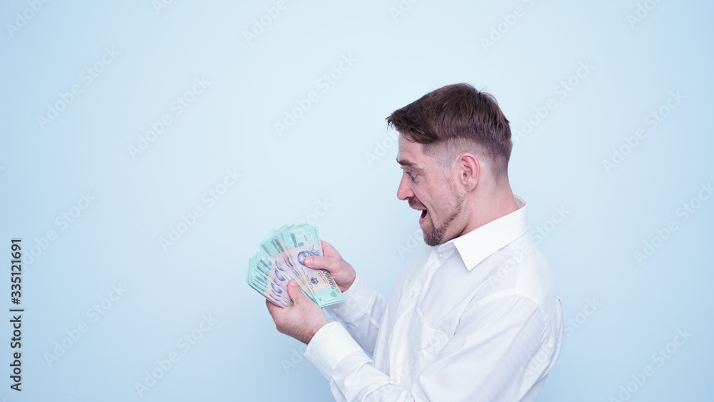 Emotional funny guy in white shirt counting vietnamese money.Portrait of young man taking Vietnam Dong money on his hand with happy emotions and smile on his face. Emotional funny guy in white shirt counting vietnamese money.Portrait of young man taking Vietnam Dong money on his hand with happy emotions and smile on his face.