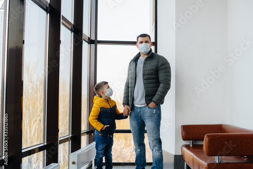 A father with his child stands in a mask during the quarantine. Pandemic, coronavirus