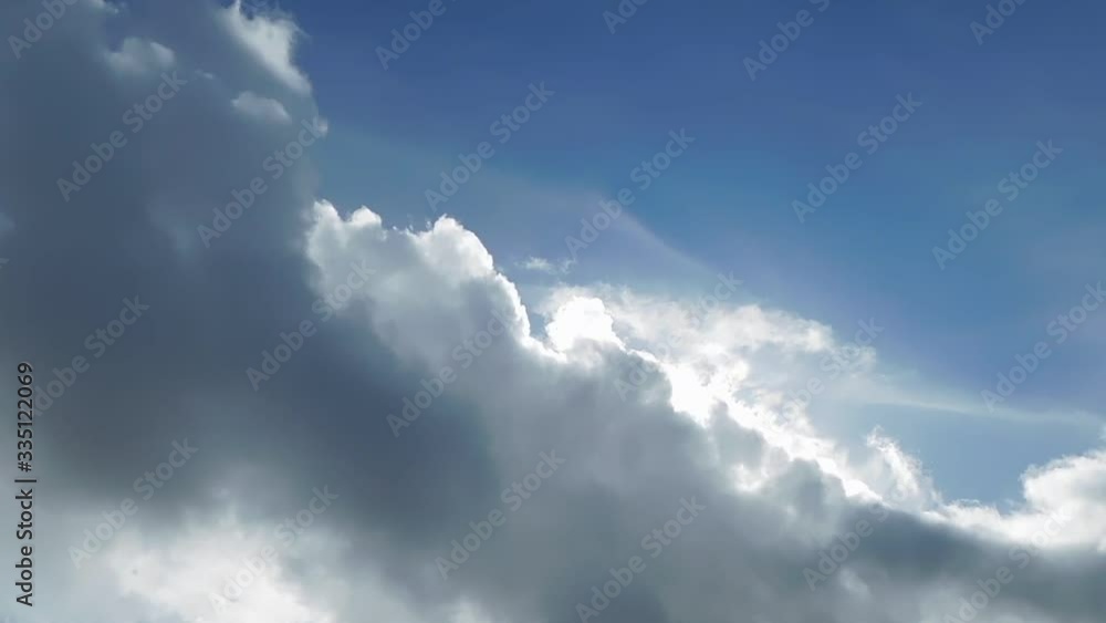 large white and grey cloud illuminated in fast motion in a blue sky large white and grey cloud illuminated in fast motion in a blue sky