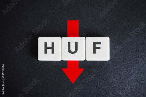 Hungarian forint alphabetic currency ISO code (HUF) and down red arrow on black background. Economy of Hungary.