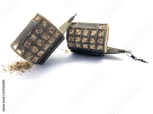 Fishing troughs and fish bait isolated on white background. Set of fish feeders. Fishing tools. Carp fishing lure. Plastic pouch.  