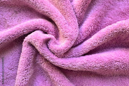 Soft fabric background. Terry towel, close-up. Soft fabric of pink, lilac colors. Texture.